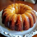 A freshly baked Breakfast Bundt Cake with a golden crust, topped with powdered sugar and berries.