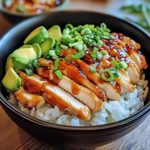 A mouthwatering Chicken Rice Bowl topped with grilled chicken, creamy avocado, and a sweet-savory glaze, served over a bed of rice.