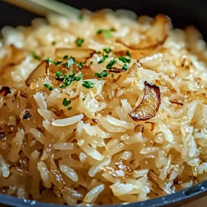 Baked French Onion Rice with golden cheese crust and fresh herbs on top.